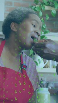 Vertical video: Chef red apron tasting bite from man giving to taste dish, binary overlay tracking