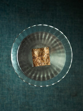 Metallic object rests in clear glass bowl