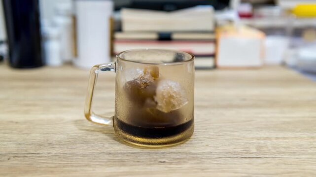Time-lapse of frozen coffee melting inside a cup.