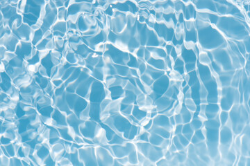 Fototapeta premium Blue water with ripples on the surface. Defocus blurred transparent blue colored clear calm water surface texture with splashes and bubbles. Water waves with shining pattern texture background.