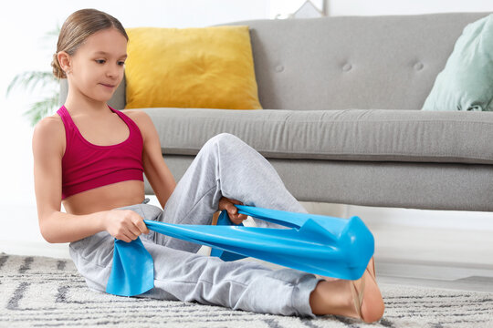 Cute gymnast with stretching tape at home