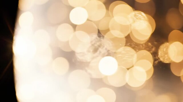 A blurry background of shimmering gold lights on a dark setting