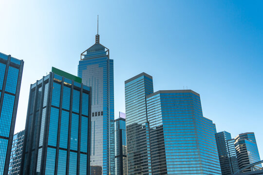Low angle view of modern skyscrapers against clear blue sky in financial district, showcasing urban architecture, business growth, corporate environment and future city development concept