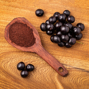 Euterpe oleracea - Exotic berries from the Amazon, showcasing the contrast between the whole fruit and the processed powder