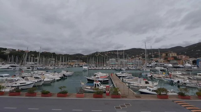 Boats and yachts docked in the harbor of Varazze, Liguria, Italy, with hills in the background