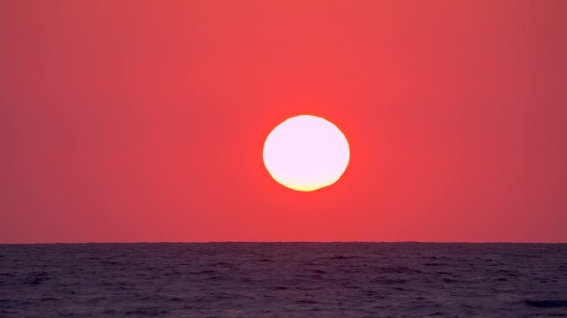 Timelapse of scenic sunset over the sea. Sun settling down time lapse. Vibrant color nature background. Golden hour at the beach. Summer evening on coastline. 4K footage.