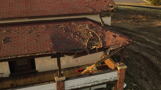 Aerial close up of damaged house roof with structural damage and debris in Wisconsin. Broken shingles and deterioration of residential building requiring repair.