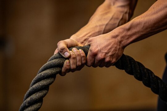 Hands gripping thick rope