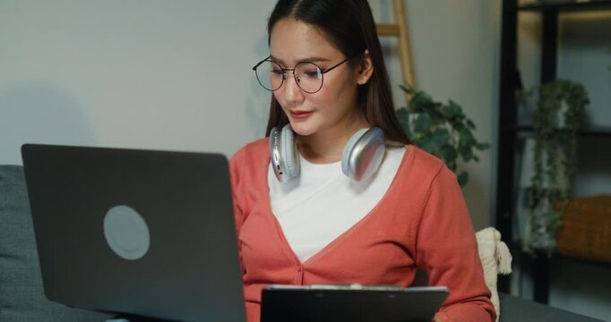 A stressed Asian professional focuses on revenue planning and investment strategies, analyzing datum on her computer at night.