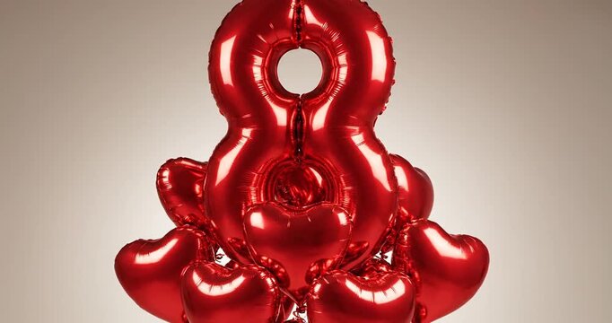 A cluster of shiny red balloons shaped like the number eight, set against a neutral background