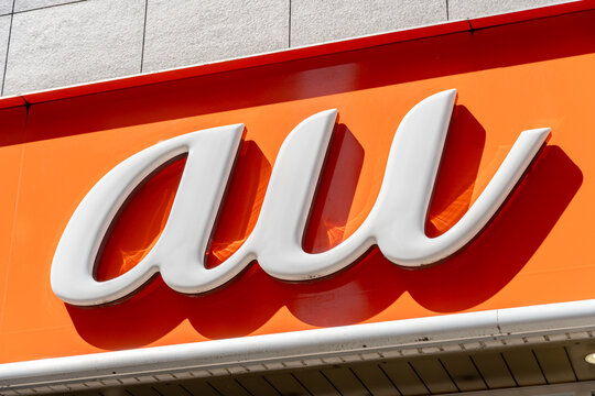MUSASHINO, TOKYO, JAPAN - MARCH 24, 2026: A close-up of the orange branding logo sign for au, a major Japanese mobile telecommunications operator, in Musashino, Tokyo.