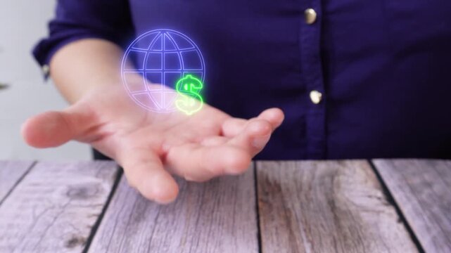 E-commerce and digital finance. Close-up of a woman's hand at a table holding a virtual globe icon with a dollar sign.
