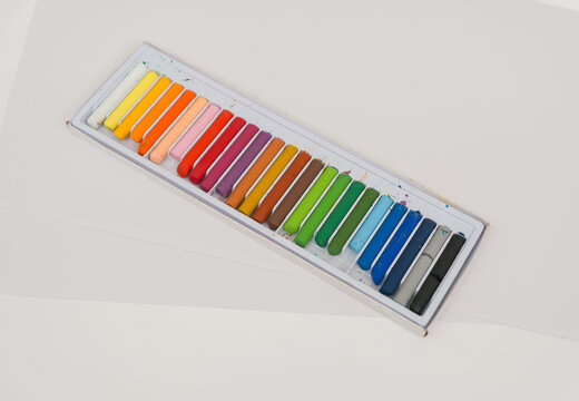 Set of oil pastels in box with white paper. Crayons