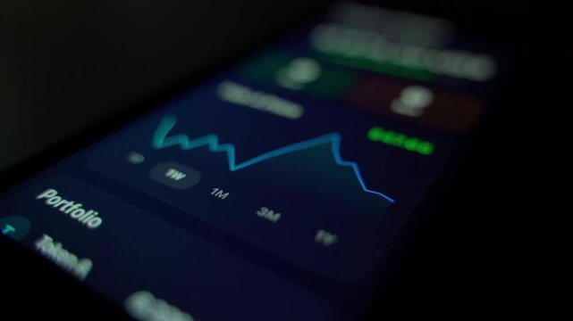 Cryptocurrency price fluctuation chart on smartphone screen in dark room close-up