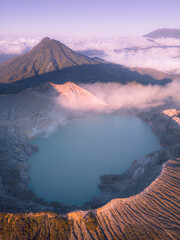 Fototapeta premium Majestic mount ijen volcano crater with turquoise sulfur lake illuminating under sunlight