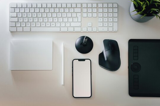 Modern wireless computer keyboard and mouse equipment sits on a black office desk representing essential technology for business communication and data work on a desktop PC or laptop notebook