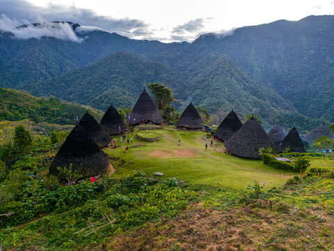 Aerial view of Wae Rebo village in Flores, Indonesia, showcasing traditional conical Mbaru Niang houses surrounded by lush green forest