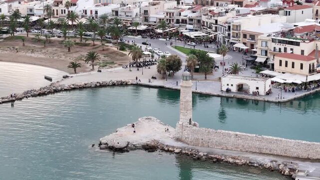 Scenic aerial footage of the old venetian harbor and lighthouse in rethymno, crete, greece