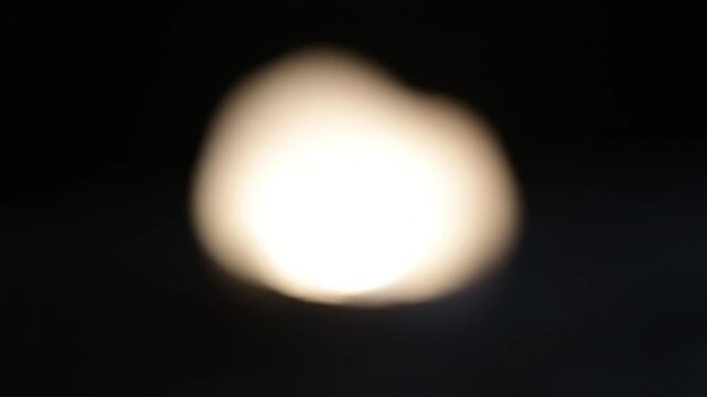 Blurry white light in darkness.