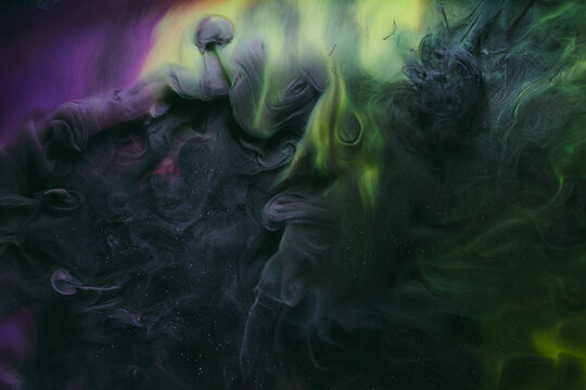 Abstract colorful green smoke on black background. Moving flow of paints, fluid liquid art, space sky