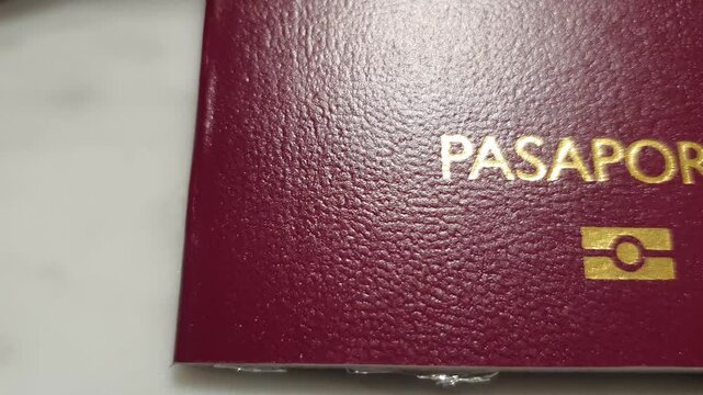 Horizontal panning footage over the letters pasaporte or passport in spanish language over a flat surface. 