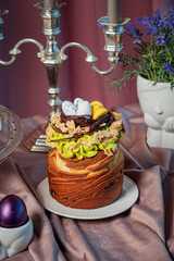 Fototapeta premium Delightful spring cake adorned with pastel eggs and fresh flowers on an elegant table setting