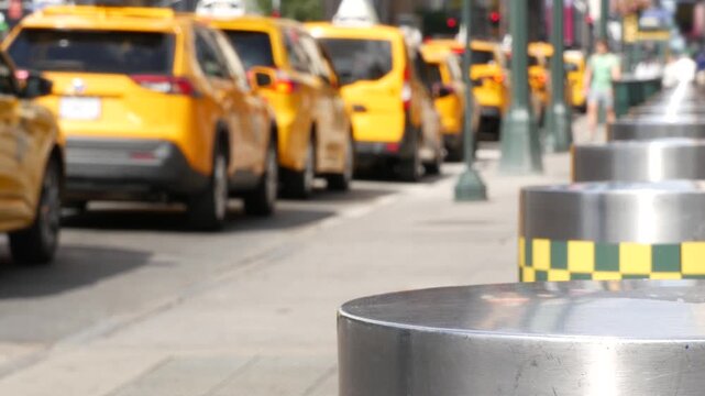 Manhattan Midtown street New York City, United States. Defocused row of yellow taxi cars. Many taxi cabs in line on 8th avenue near Penn Station. Taxi queue, urban road traffic, passenger transport.