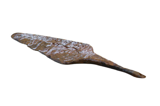 Ancient spear head made of iron. Rusted metal artifact from archaeological excavation. Historical weapon piece isolated on transparent background. Primitive combat tool from past era.