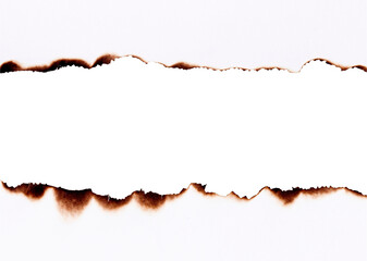 Burnt paper with torn charred edges forming a damaged border frame isolated on white background