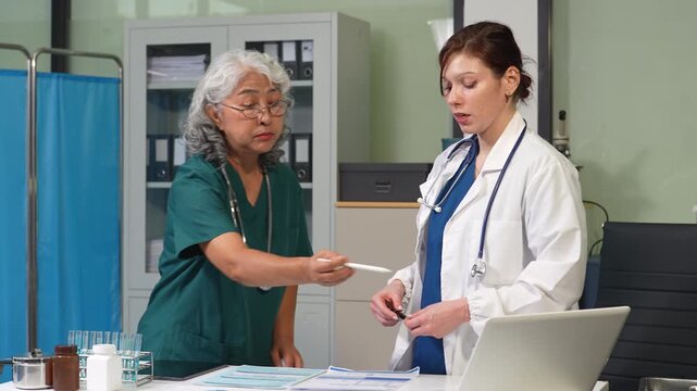 Medical team working with a tablet and Laptop computer search for medical information at the hospital office.