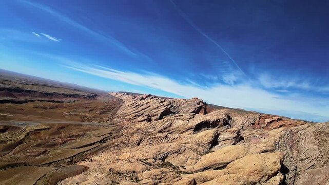 Cinematic aerial landscape of barren sandstone cliffs resembling an alien planet surface