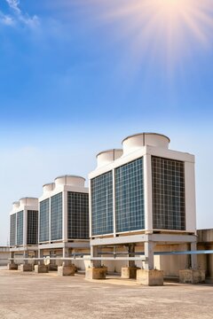 Industrial chillers aligned on flat rooftop under bright midday sun