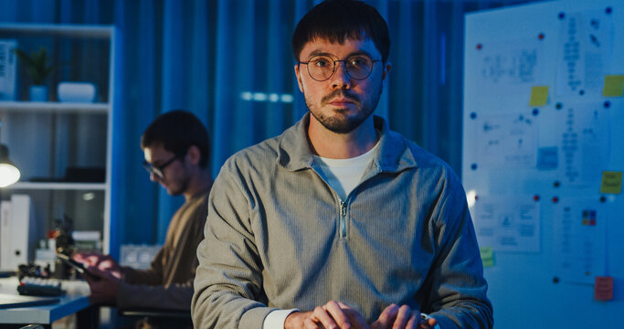 Team adult male freelance developer work late typing write prompt AI bot app program nomad terminal code at office night. Artificial intelligence dashboard, robotics, user interface, machine learning.