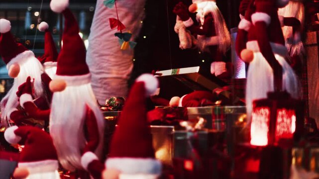 Christmas gnomes and santa claus dolls moving with gifts, lanterns on christmas market in motion.