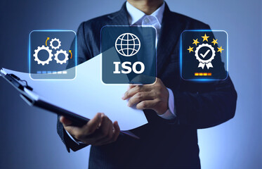 ISO certified concept with businessman holding document clipboard to open paper check out detail for products and system certification to complies standards requirement
