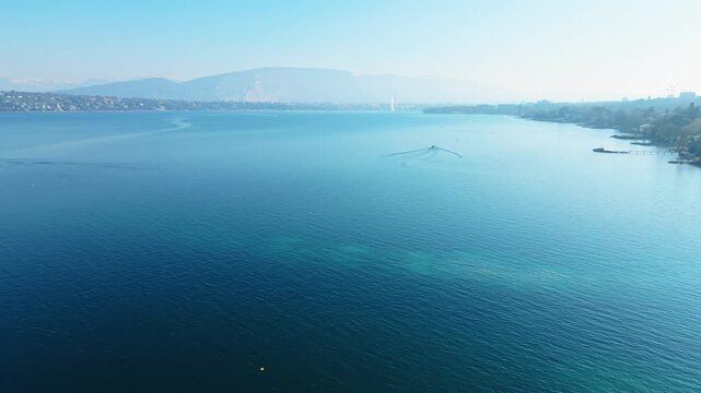 Aerial: Lake Geneva during the day with water fountain in the back in Geneva, Switzerland, reveal drone shot
