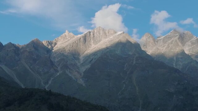 Cinematic aerial sweep of majestic jagged mountains and deep shadows near Chitkul, Kinnaur, Himachal Pradesh