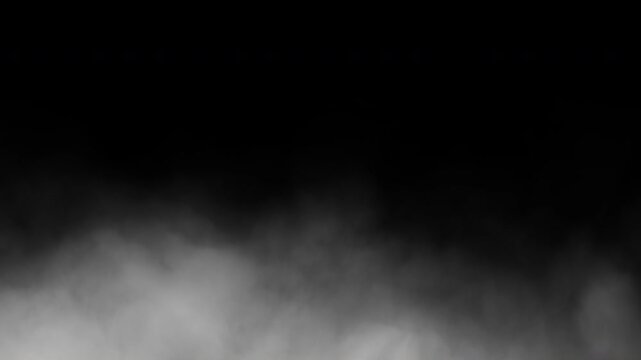 Cinematic fog or smoke billowing across the ground against a black background. Seamless animation in 4K resolution.