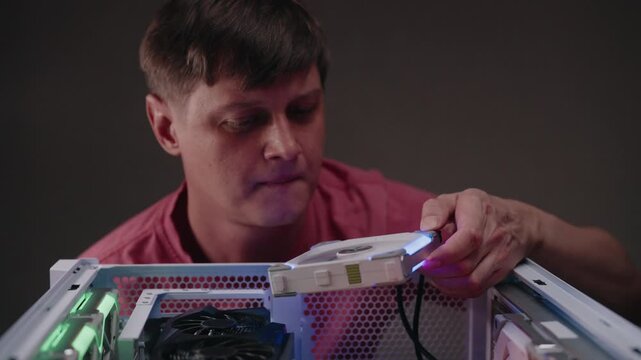 Professional technician installing powerful rgb cooling fan into custom built gaming pc for optimal performance, maintenance, ensuring proper airflow and thermal regulation for peak system efficiency.
