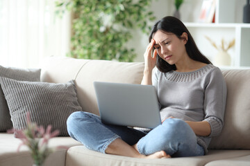 Worried asian woman complaining about online content