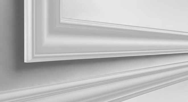 Close up of white decorative moulding baseboard in empty modern room interior detail trim wall panel design stockon black background