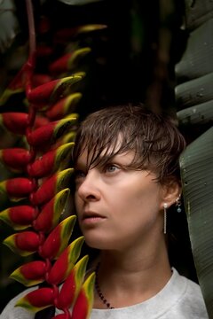 Woman with Short Wet Hair Looking Up Between Heliconia and Banana Leaf