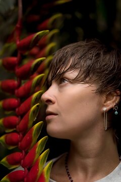 Side Profile Portrait of Woman with Short Hair Near Heliconia Flower