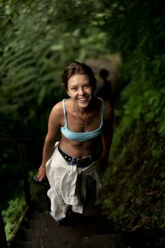 Happy Woman Hiking Up Jungle Stairs Laughing Nungnung Waterfall Bali