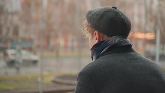 White creator turns head toward camera at waterfront rail, cold breath and raindrops, sharp focused gaze in closeup, beret and scarf, urban park backdrop, intense expression, indie director and model