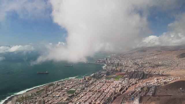 Drone reveal through dense fog showing Antofagasta city, Chile. Regional Stadium, Pacific Ocean and ships. 4K 10-bit DJI Mini 4 Pro cinematic aerial shot.