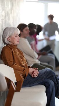 Mature woman in lobby of job center or employment office, waiting for interview or conversation with career counselor. High quality 4k footage