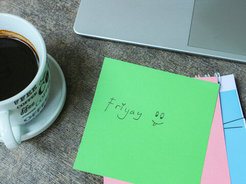 Coffee Mug with Friyay Note Card and Laptop on Wooden Desk