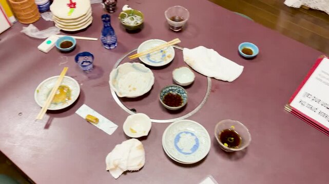 Empty Plates and Leftovers on a Traditional Japanese Izakaya Dining Table