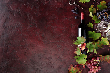 Fototapeta premium Red Wine Bottle with Grapes and Vine Leaves on Rustic Background